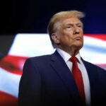 TRUMP Pardons Top Aides BEFORE Crimes Charged… donald trump in suit with red tie American flag backdrop