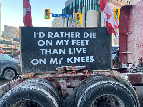 shutterstock_2118058559.jpg A protest sign on a truck displaying a bold statement about freedom and resilience