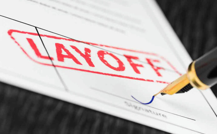 1164531244 Layoff notice being signed with a pen.