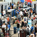 Airlines Deploy BRUTAL Pricing Strategy on Families… Crowd at an airport security checkpoint with TSA officers.