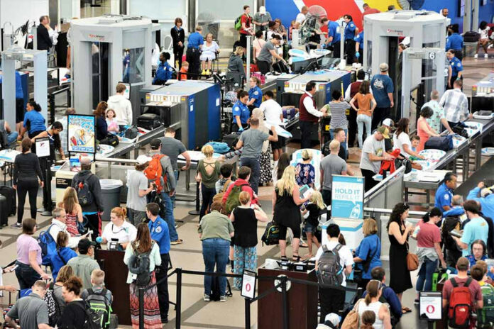 1463547893 Crowd at an airport security checkpoint with TSA officers.