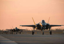 Jets on runway at sunset.