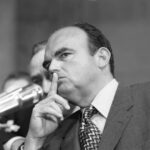 Fuhrman’s DEATH Reignites O.J. SCANDAL Fire A serious man with a finger to his lips, indicating silence, during a congressional hearing