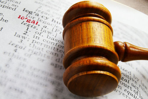 Gavel on book page highlighting the word legal.