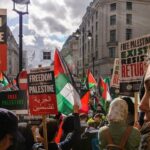 Police RAID Rocks SOCIALIST Party Headquarters… Crowd of protesters holding signs and Palestinian flags during a rally for Palestinian freedom