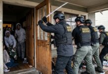 Law enforcement officers conducting a property recovery raid