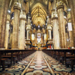 Priest’s SHOCK Praise for Pro-Abortion Star… Interior of a grand cathedral with empty pews.