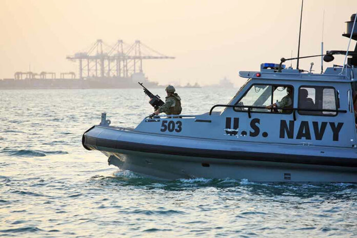 389280448-2 U.S. Navy patrol boat on water near industrial port.