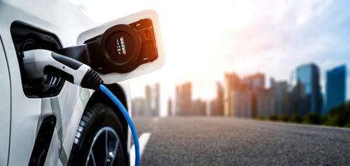 shutterstock2021600951-1jpg Electric car charging with city skyline background.