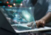 Person using laptop with futuristic data and analytics interface