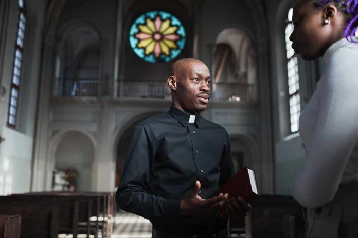 Priest talking with a visitor inside a church