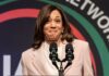 No Ballots, Just Power: Harris Anointed Female speaker smiling at a podium with microphones