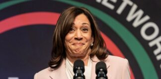 Female speaker smiling at a podium with microphones
