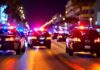 Police cars with flashing lights on a city street at night