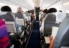 Airplane cabin with passengers seated in rows