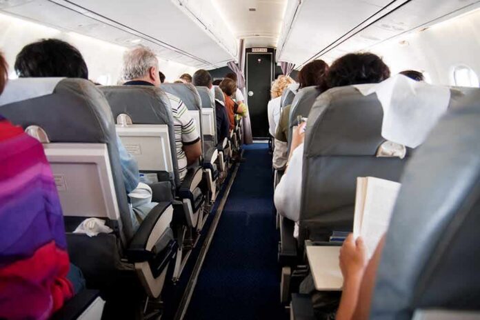 Airplane cabin with passengers seated in rows
