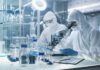 Examiner Identifies Cause Behind Graham’s Fatal Aortic Tear Scientists in protective suits using a microscope in a laboratory