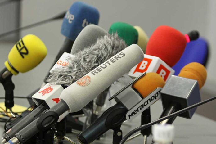 Cluster of various microphones at a press conference.