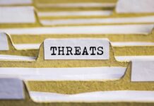 File tab labeled "THREATS" in a folder.