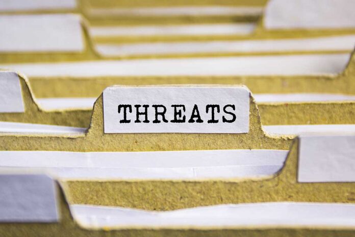 File tab labeled "THREATS" in a folder.