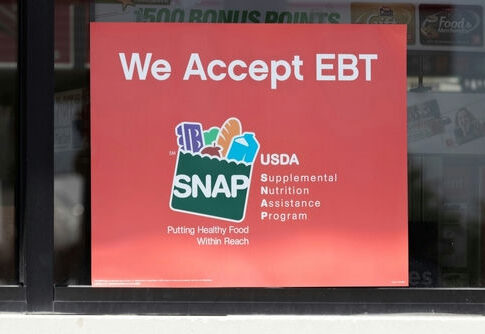 Red sign on a storefront window announcing acceptance of EBT and SNAP benefits