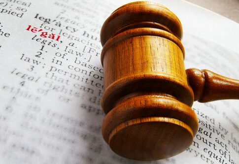Gavel on book page highlighting the word legal.