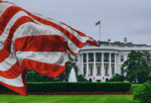 U.S. flag waving in front of the White House.