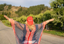 Person wearing Make America Great Again hat and American flag.