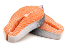 Two raw salmon steaks on a white background.