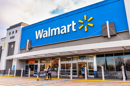 Walmart storefront with people and shopping carts outside.