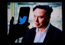 A phone with Twitter logo against Elon Musk's image.