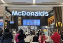 People standing in line at McDonald's inside mall.