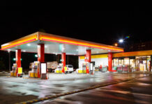 Illuminated gas station at night with a convenience store.