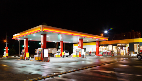 Illuminated gas station at night with a convenience store.